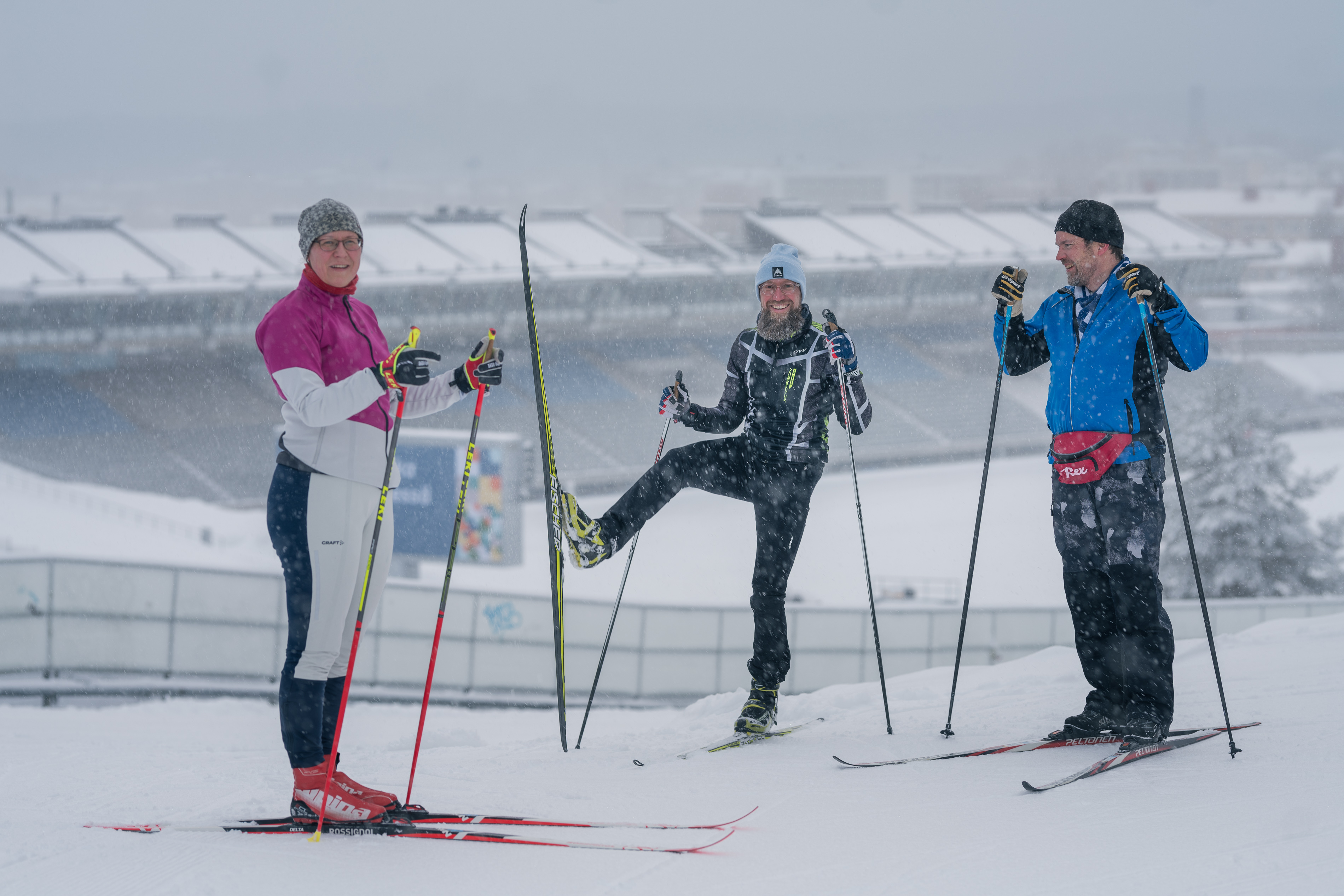 Kolme hiihtäjää Lahden urheilukeskuksessa. Yhteisvastuuhiihdon kampanjakuva.