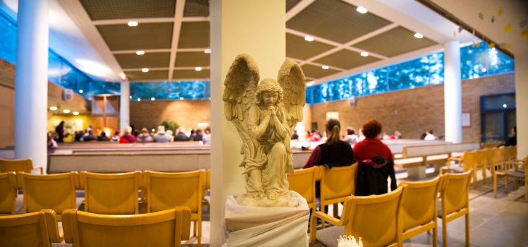 Salpausselän kirkon sisäkuva. Etualalla enkeliveistos.