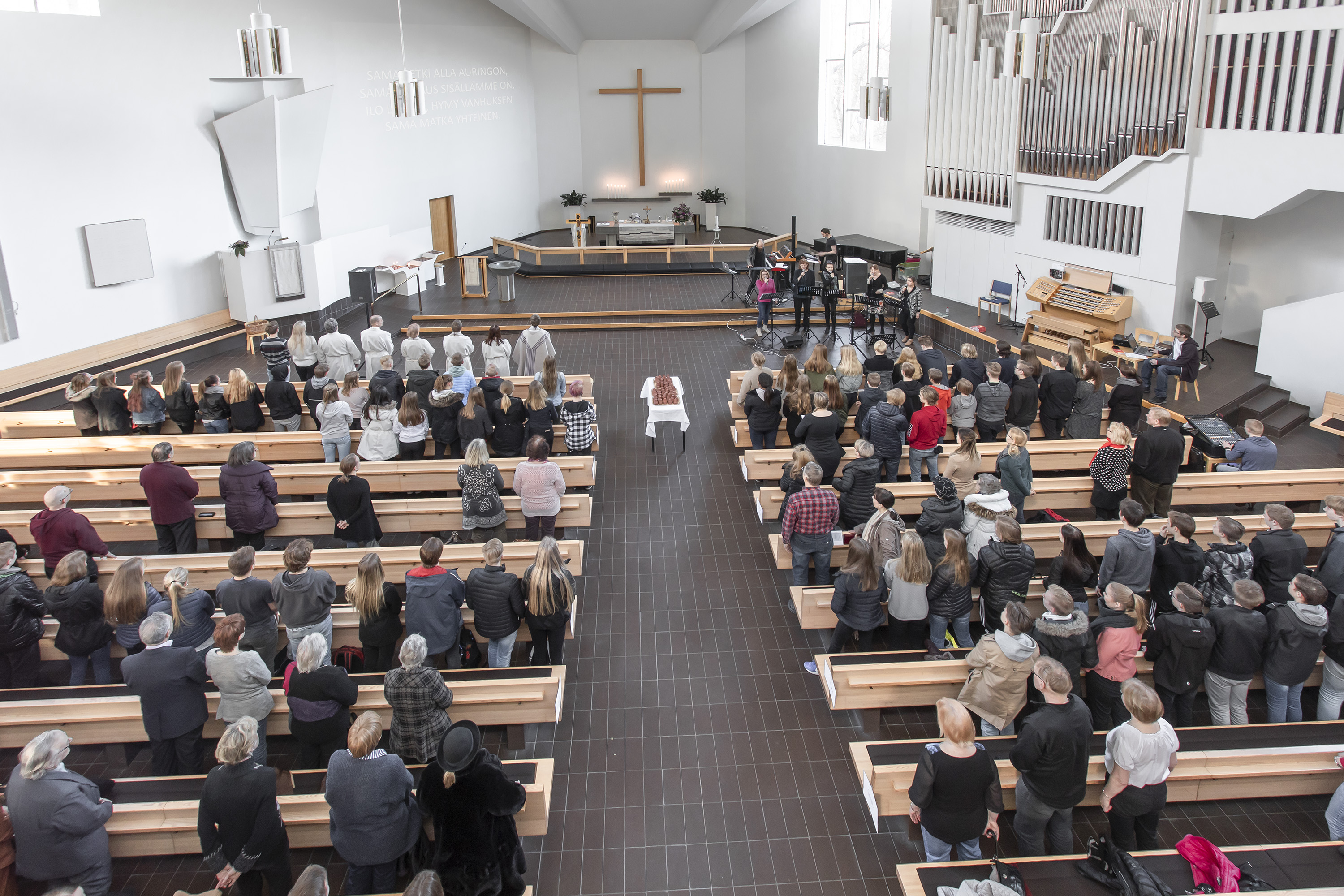 Sisäkuva Lahden Ristinkirkosta. Kirkkosalissa runsaasti seurakuntalaisia.