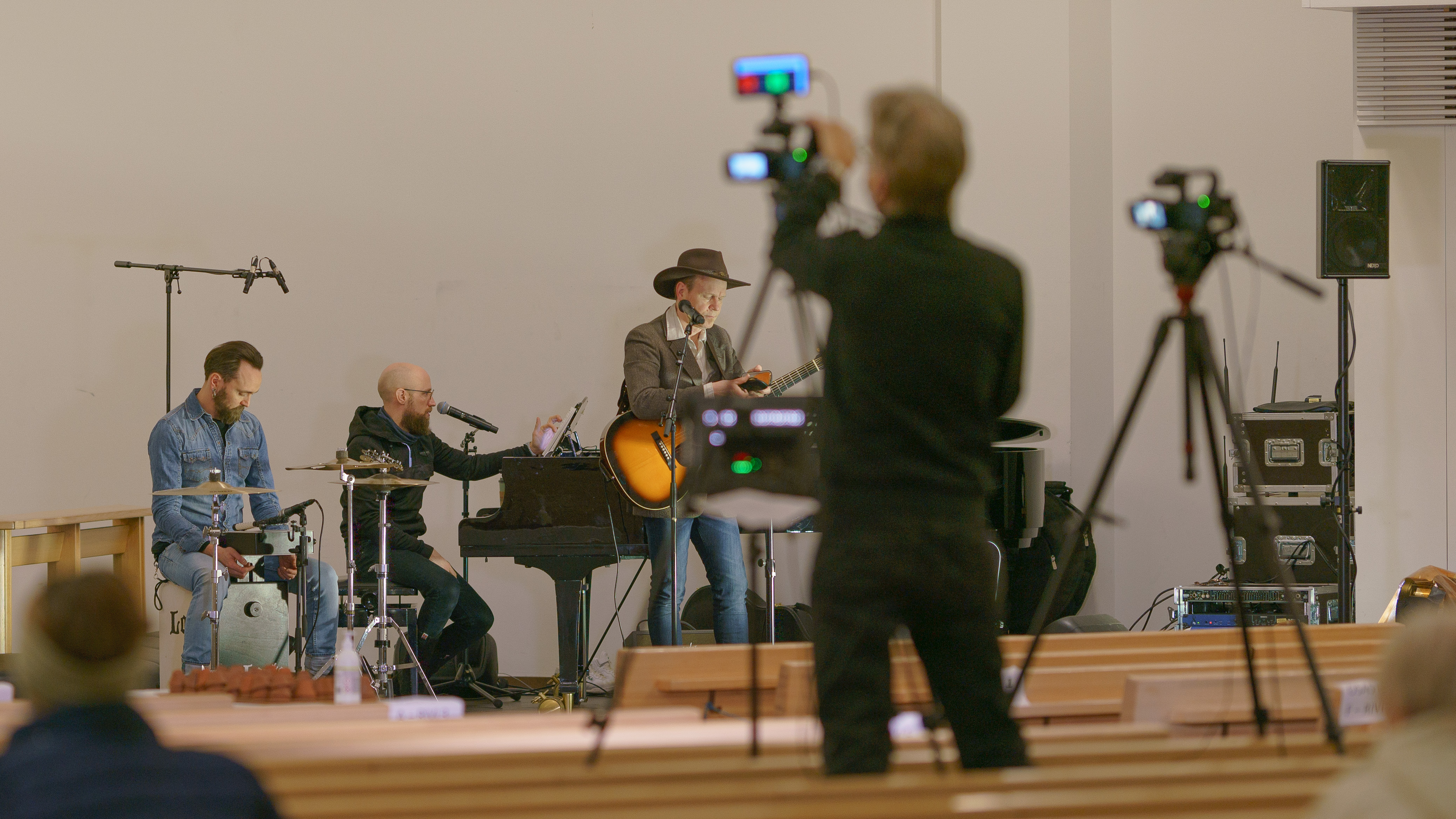 Kuvassa on videokuvauskalusto ja ihmisiä Lahden Ristinkirkossa.