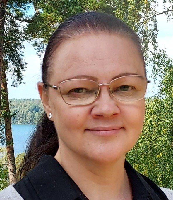 Hanna Hyttinen hymyilee luonnon keskellä otetussa kasvokuvassa.